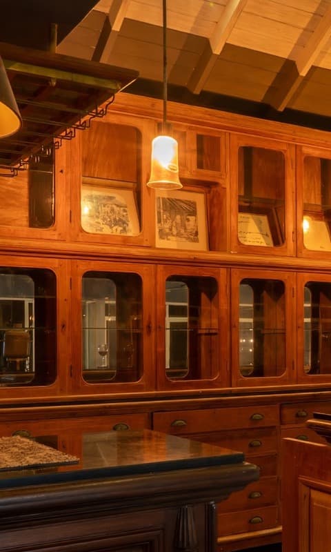 Antique wood-and-glass display cabinet in the bar
