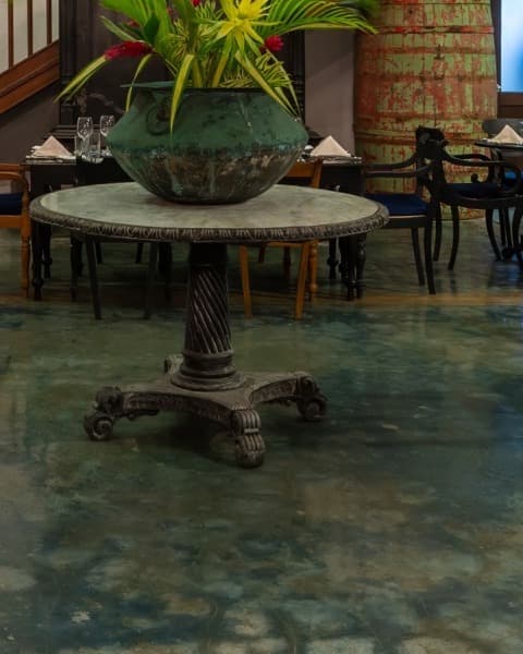 Cast-iron pedestal table topped with a verdigris urn
