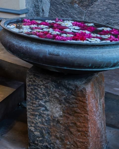 Ceramic urn with floating flowers at the entrance