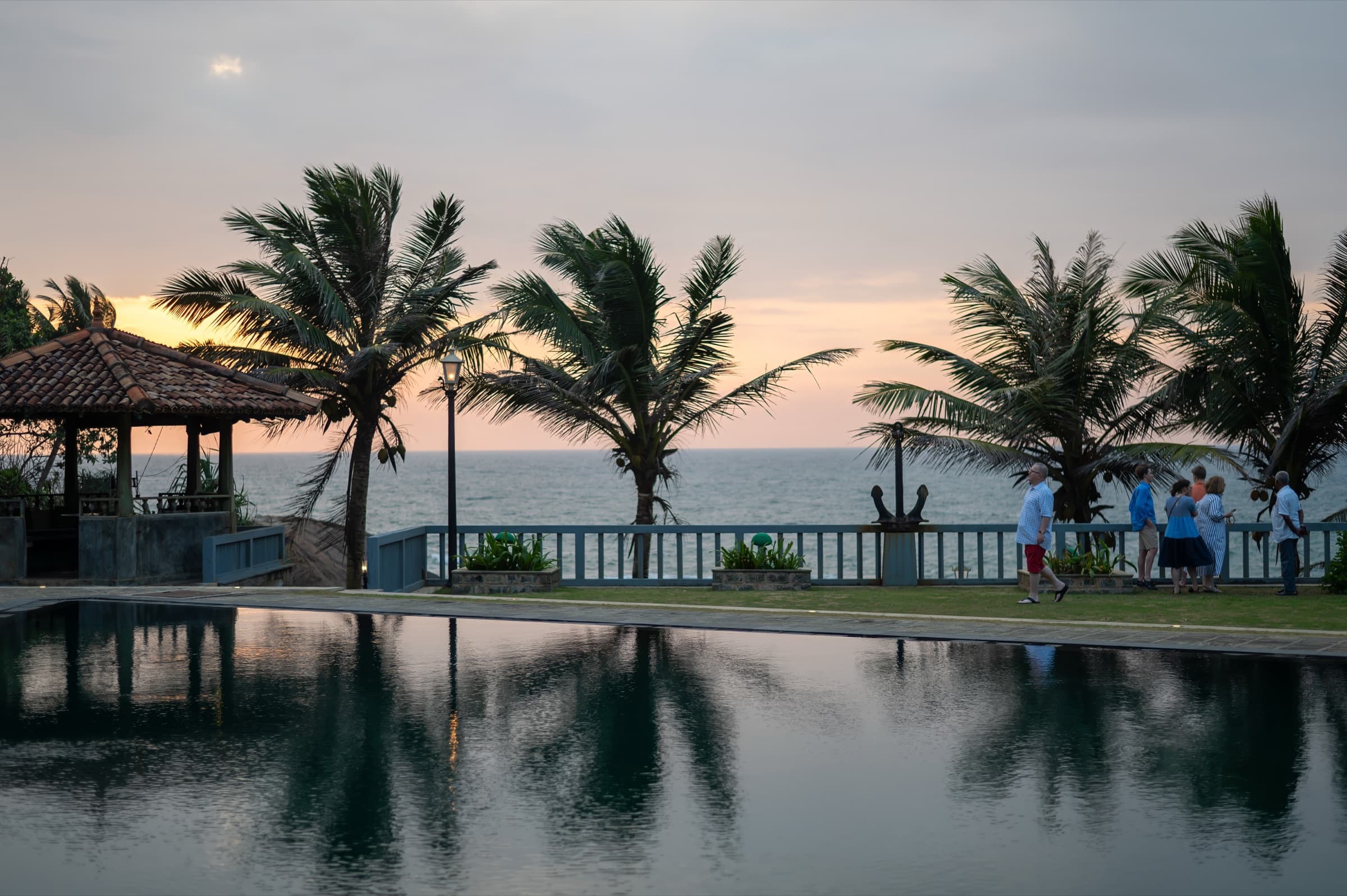 Pool at Two Anchor reflecting palms at dusk