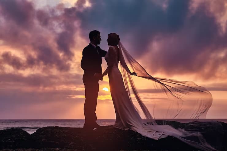 Couple celebrating together on the beach at sunset